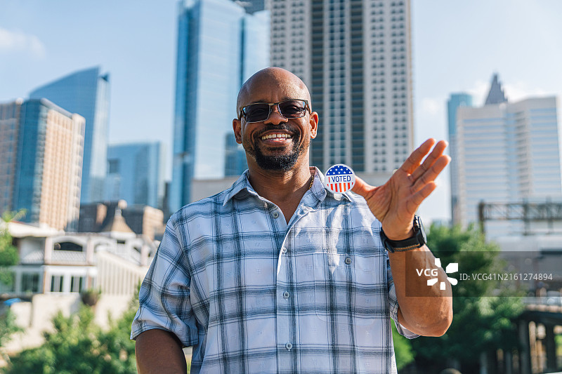 在休斯顿手持“我已投票”贴纸的非裔美国男人，参加总统、参议员、国会或地方选举图片素材