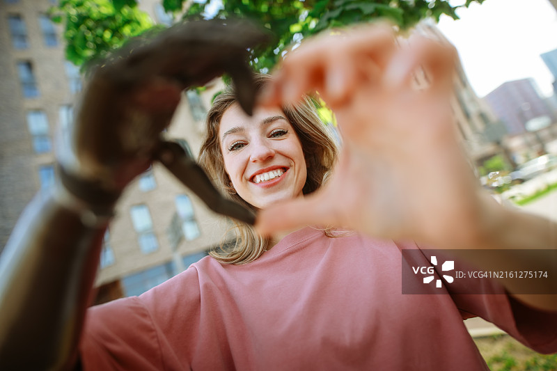 一名戴着义肢的中年妇女在一幅肖像中用手指画出了一颗心图片素材