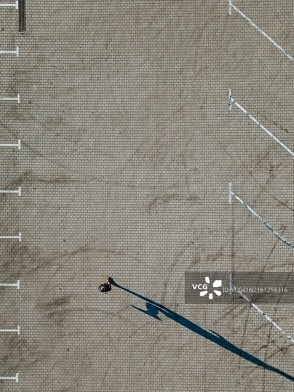 停车场阴影跑：男人穿过停车场，阳光下阴影跟随。直接上方图片素材