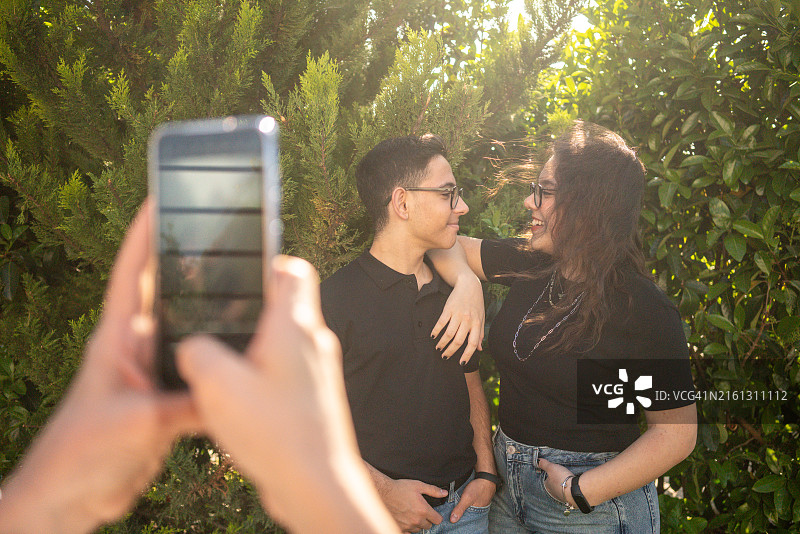 花园背景中拍照的青少年男女图片素材