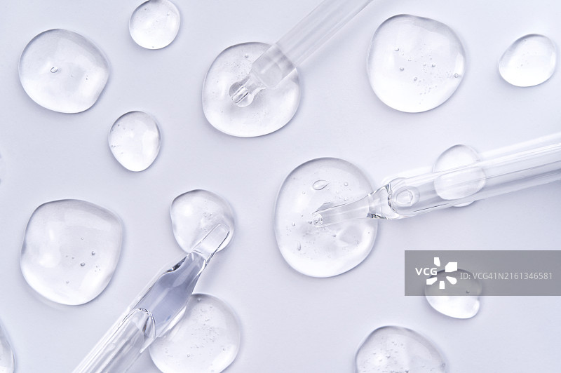 在白色背景上使用玻璃滴管涂抹多种凝胶样品，科学实验室中的化学研究，微距摄影，扁平风格图片素材