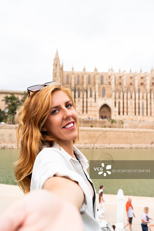 年轻女游客在主教座堂前牵着男友的手图片素材