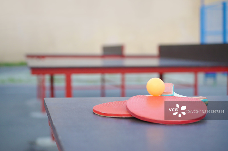 户外乒乓球台上的球拍和球图片素材