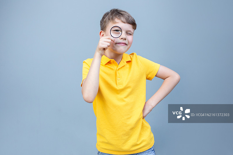 手持放大镜的可爱男孩摄影，看起来像侦探图片素材