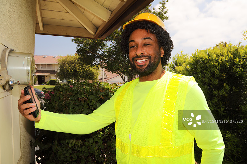 校准相机眼睛的非裔美国智能电表工人图片素材