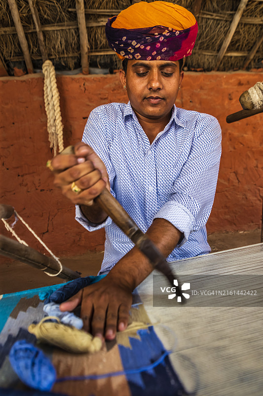 在拉贾斯坦邦编织纺织品（地毯）的印度男人图片素材