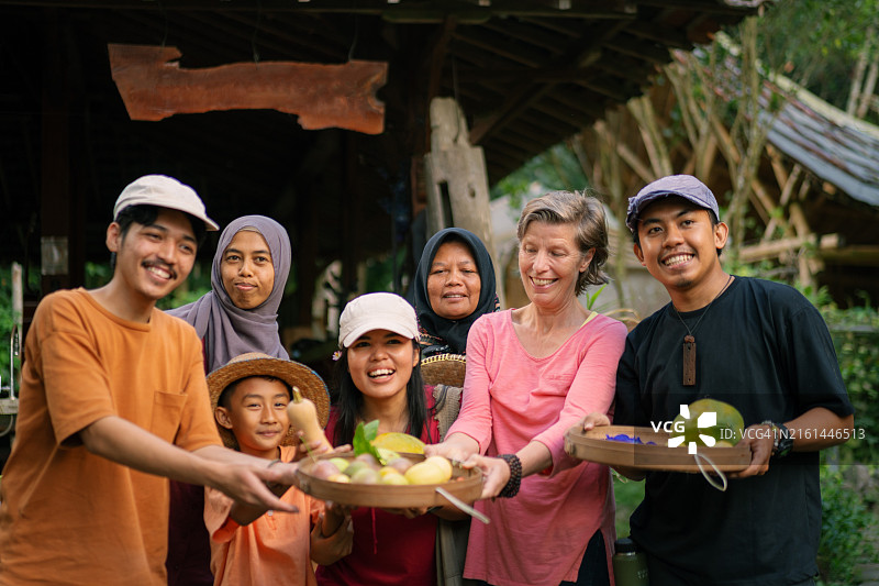 一群人 carrying 在竹篮板条箱上收获的水果和蔬菜图片素材