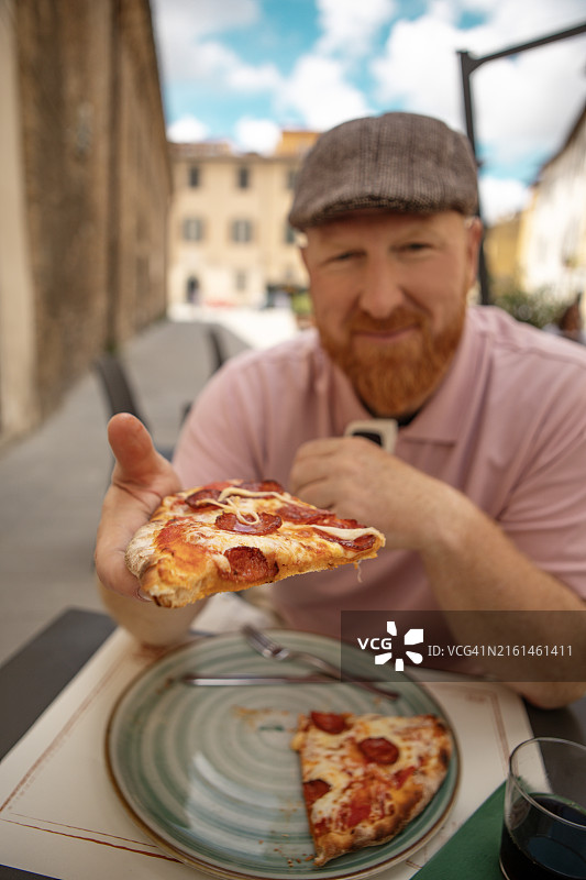 在意大利享用披萨的英俊红发男人图片素材