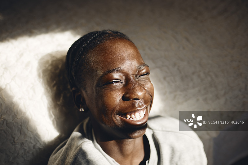 快乐的青少年男孩在家中床边眨眼图片素材