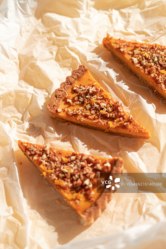 揉皱的包装纸上放着四块核桃南瓜蛋糕，传统的感恩节和万圣节秋季菜肴，扁平风格图片素材