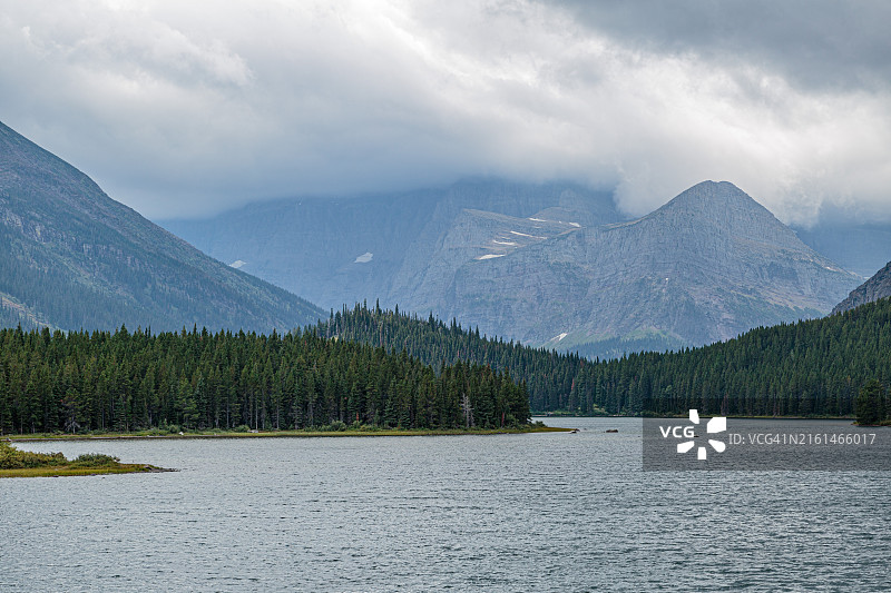 蒙大拿州冰川国家公园斯威夫特湖沿岸被云雾笼罩的山脉图片素材
