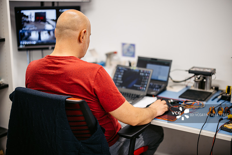 汽车修理工在办公室修理发动机控制单元图片素材