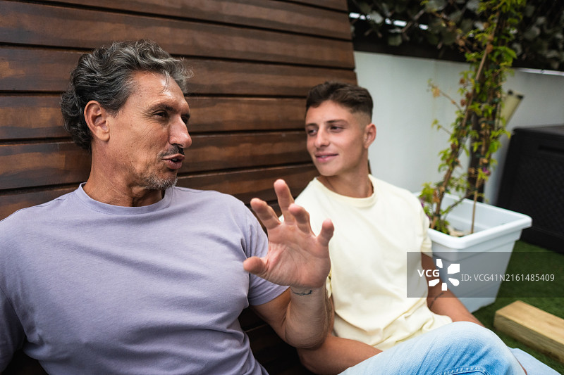 中年男人热情地向一个年轻人解释事情图片素材