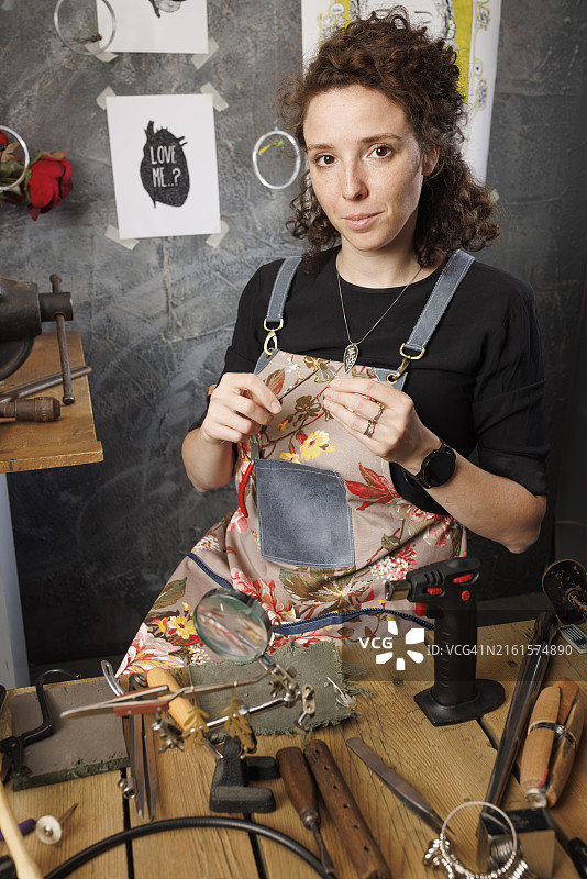 年轻漂亮的女珠宝商手工制作耳环图片素材