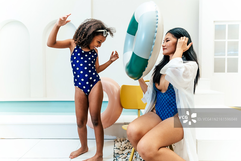 快乐的母亲和女儿在泳池边图片素材