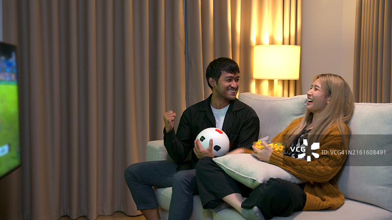 情侣在电视上看足球比赛图片素材