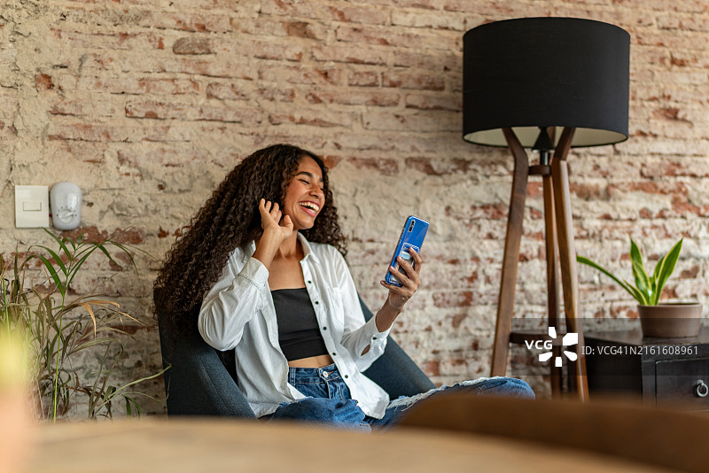 年轻女子在家中使用手机进行视频通话图片素材