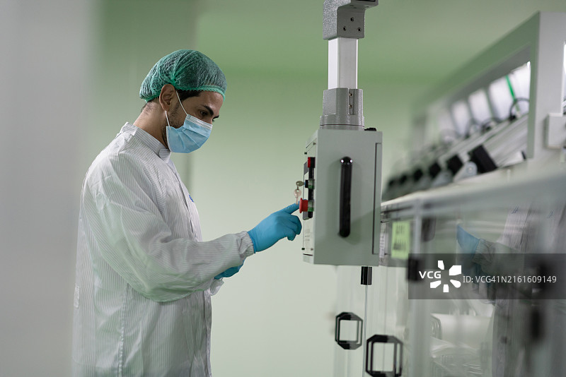 制药实验室，药剂师控制传送带机器的电脑显示器图片素材