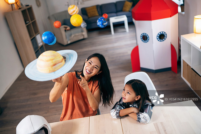 女孩和妈妈在家制作土星模型图片素材