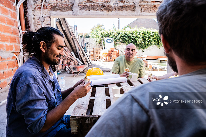 同事在建筑工地工作后休息图片素材