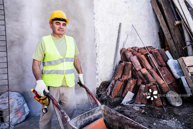 建筑工人在建筑工地推独轮车肖像图片素材