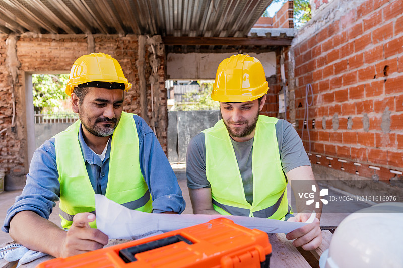 建筑工人在施工现场分析蓝图图片素材