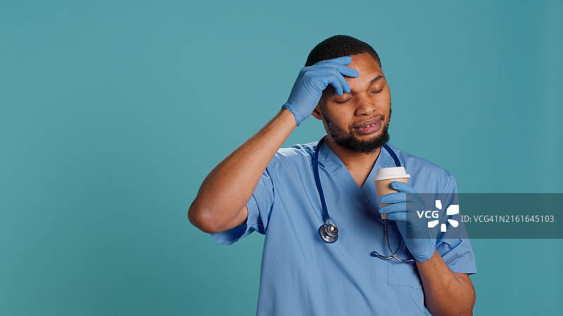 男护士在轮班休息时享用咖啡图片素材