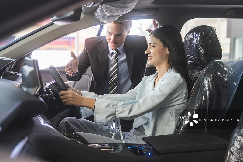 在展厅里享受豪华汽车的微笑女人图片素材