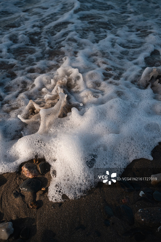 海浪拍打沙滩和石头的特写图片素材
