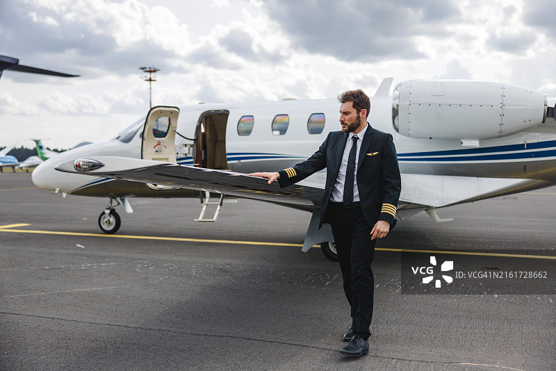 自信的飞行员在飞行前检查私人飞机图片素材