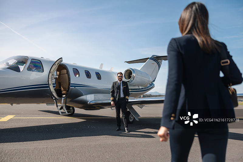 女商人和飞行员走向私人飞机图片素材