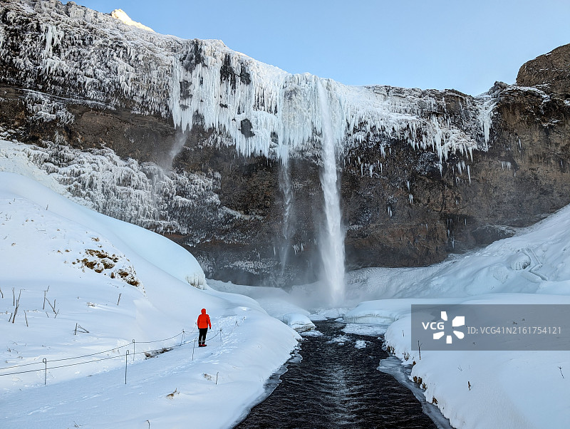 徒步者在冬季欣赏冰岛塞里雅兰瀑布图片素材