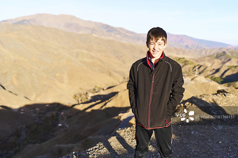 站在山上微笑看着镜头的穿夹克男孩正面人像图片素材