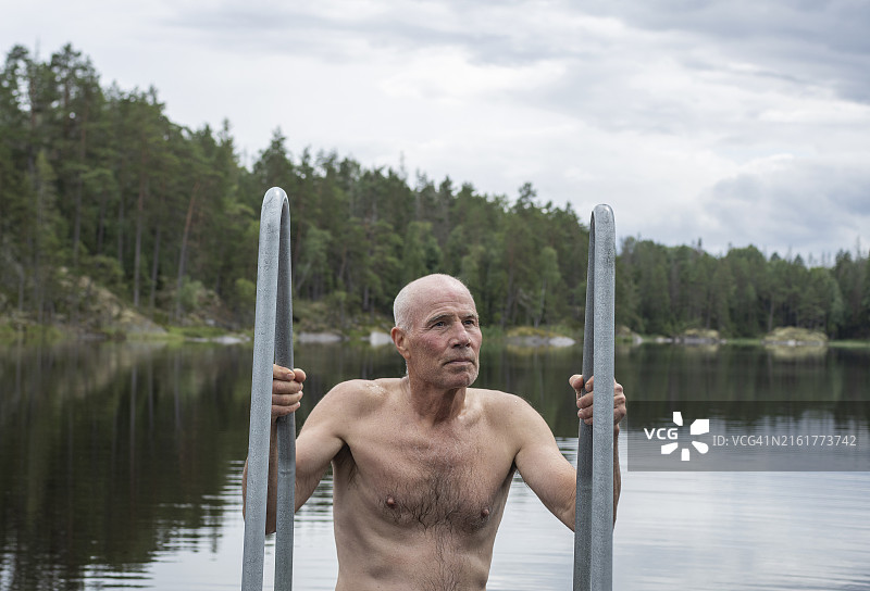 男子在森林湖泊游泳后上岸图片素材