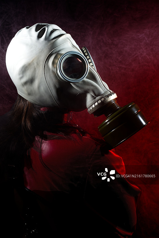 戴着防毒面具的人在红色背景下的特写侧视图，西班牙纳瓦拉潘普洛纳图片素材