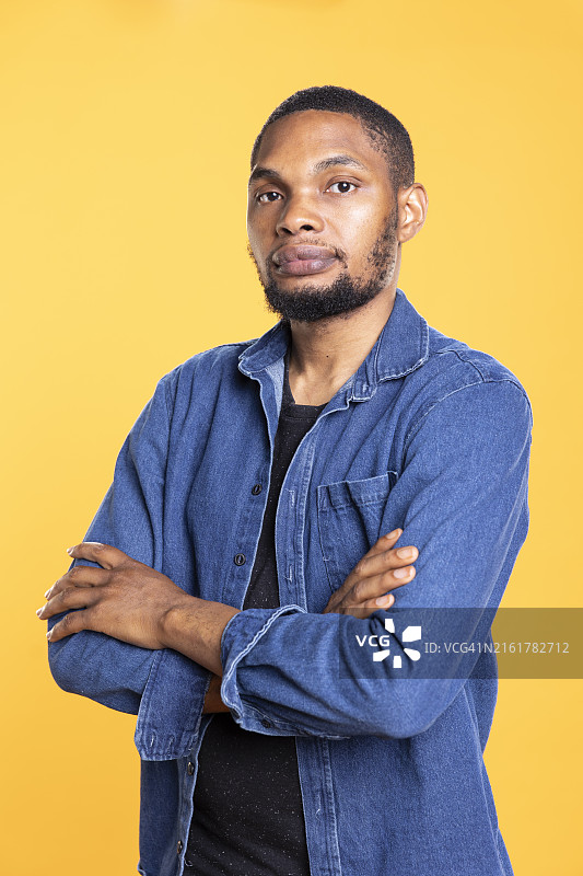 在工作室里交叉双臂的放松的非洲裔男子 портрет图片素材
