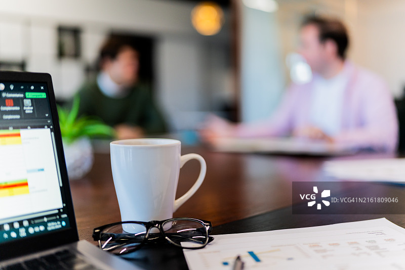 会议桌上的马克杯和眼镜特写图片素材