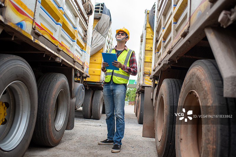 建筑工地上一辆卡车旁的卡车司机或建筑工人图片素材