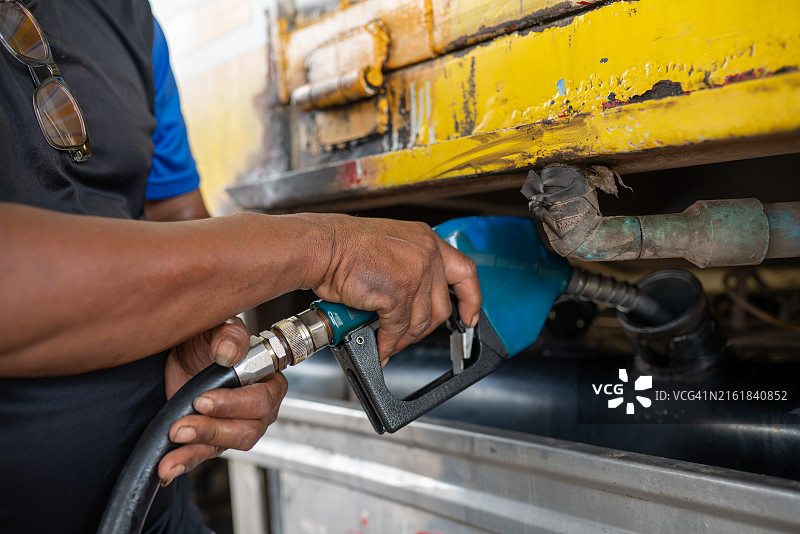 男人给黄色卡车加油图片素材