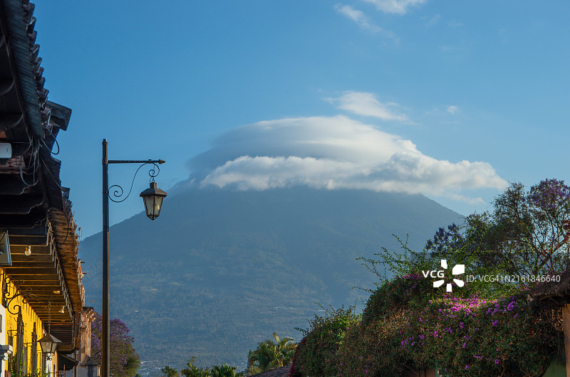在危地马拉萨卡特佩克斯省安提瓜殖民老城上空的阿卡特南戈火山顶部的荚状云图片素材