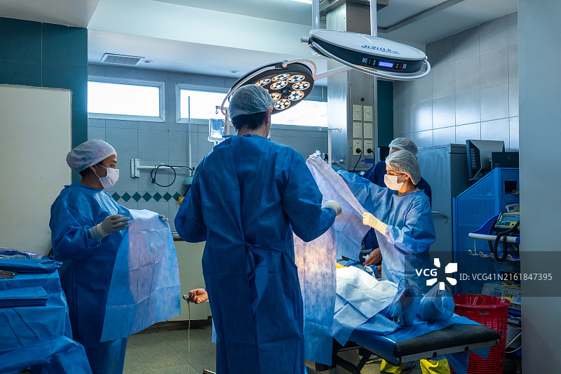 医生团队正在为患者铺手术单图片素材
