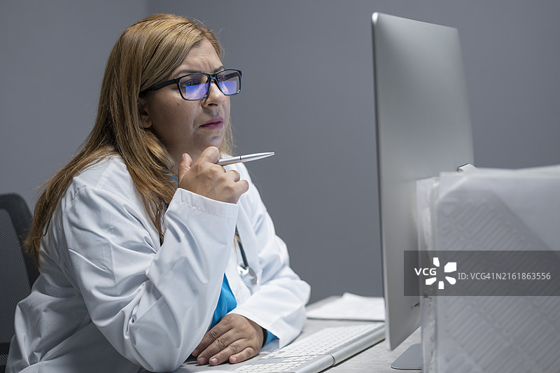 女医生在电脑屏幕上分析数据图片素材