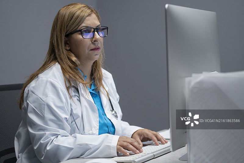 在办公室里穿着实验服使用电脑的女人图片素材