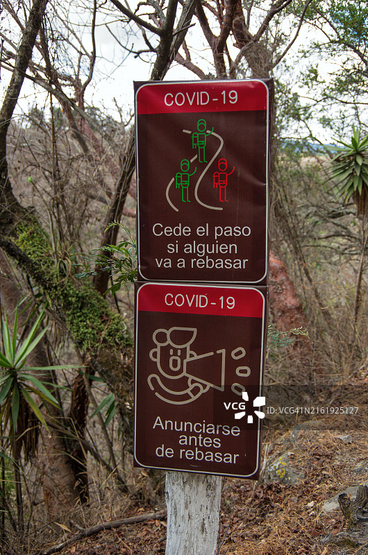 西班牙语Covid-19警告标志：行走轨道上提示“如果有人要超车，请让路”和“超车前请告知”图片素材
