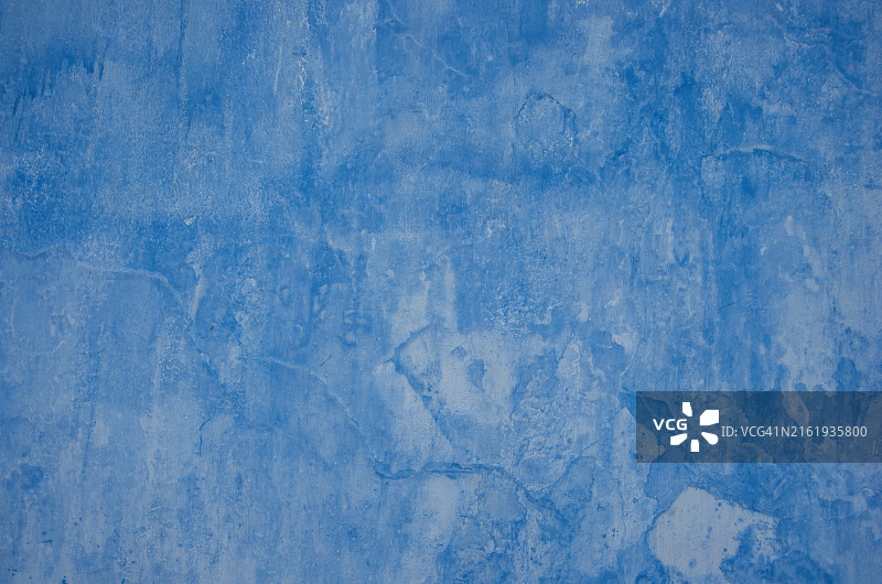 不平坦的灰泥墙上稀释的浅蓝色涂料图片素材