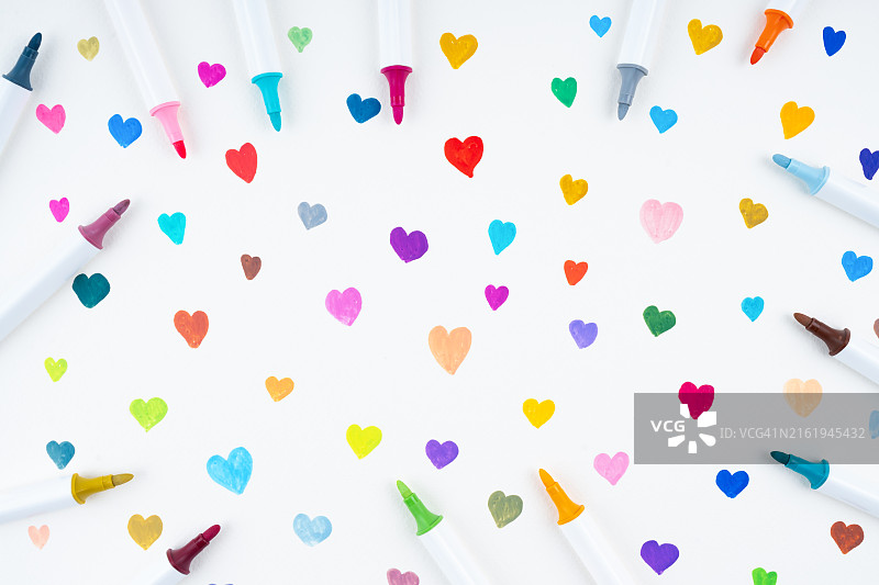 用丙烯笔在白色彩纸上画彩色心形图片素材