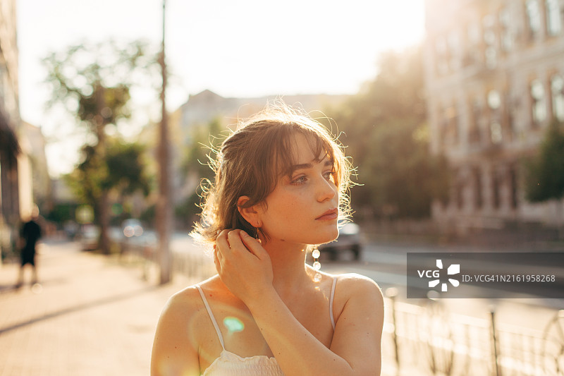 在夏季城市街道上行走的美丽年轻女人图片素材