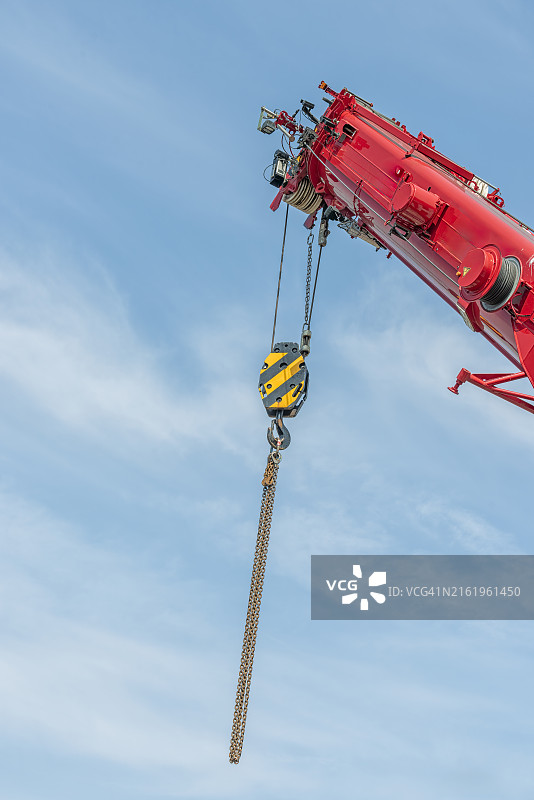 红色工业起重机悬挂的钢链图片素材