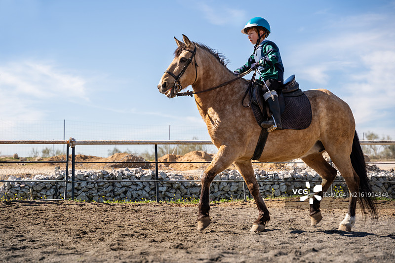 儿童在赛马场练习骑马图片素材