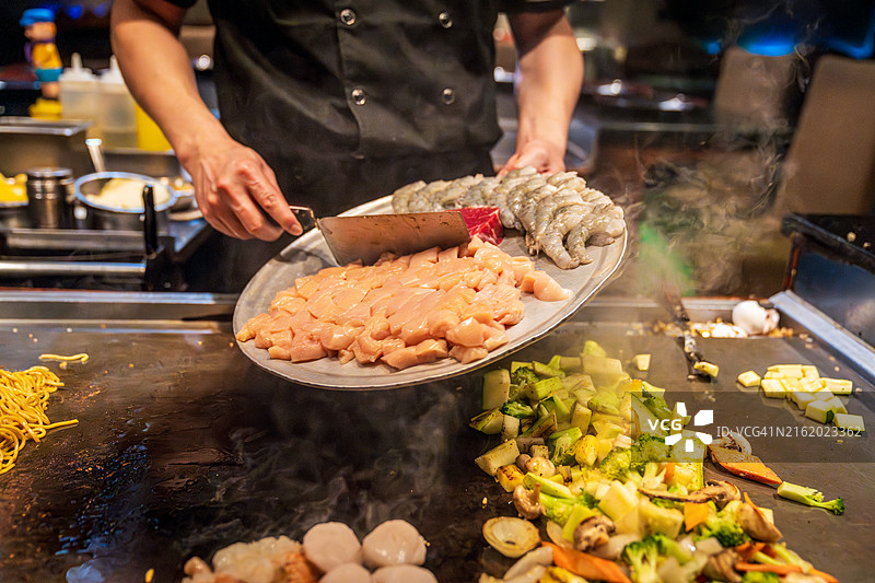 日式烧烤厨师熟练地准备烤肉和蔬菜图片素材